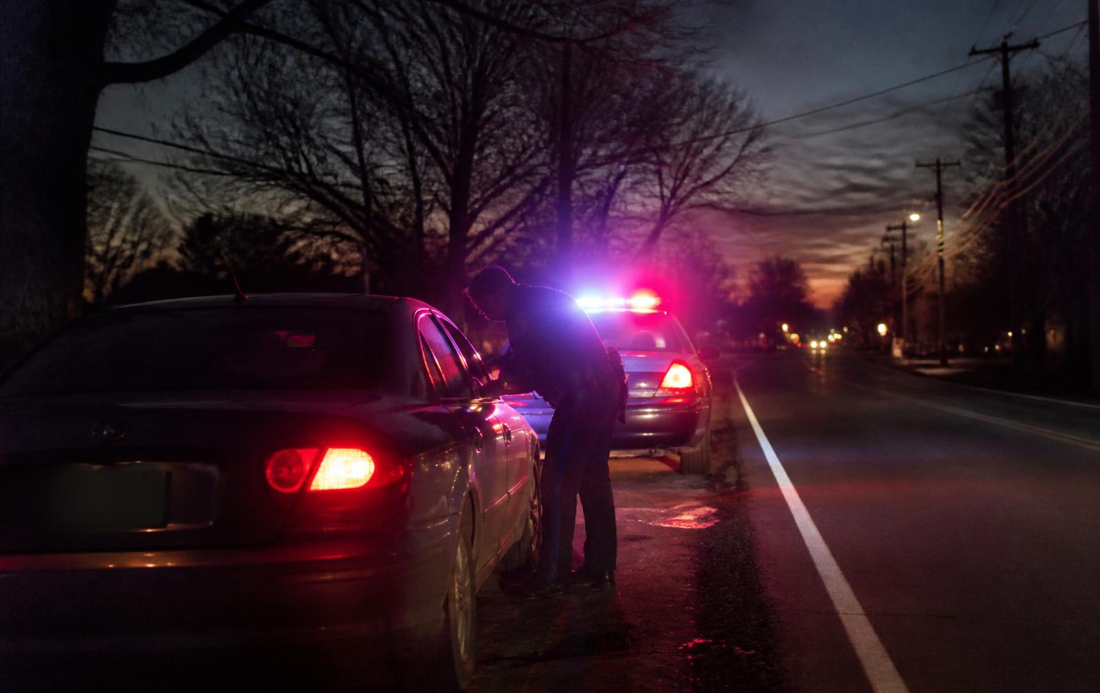 Evening traffic stop with patrol car lights on a New York road